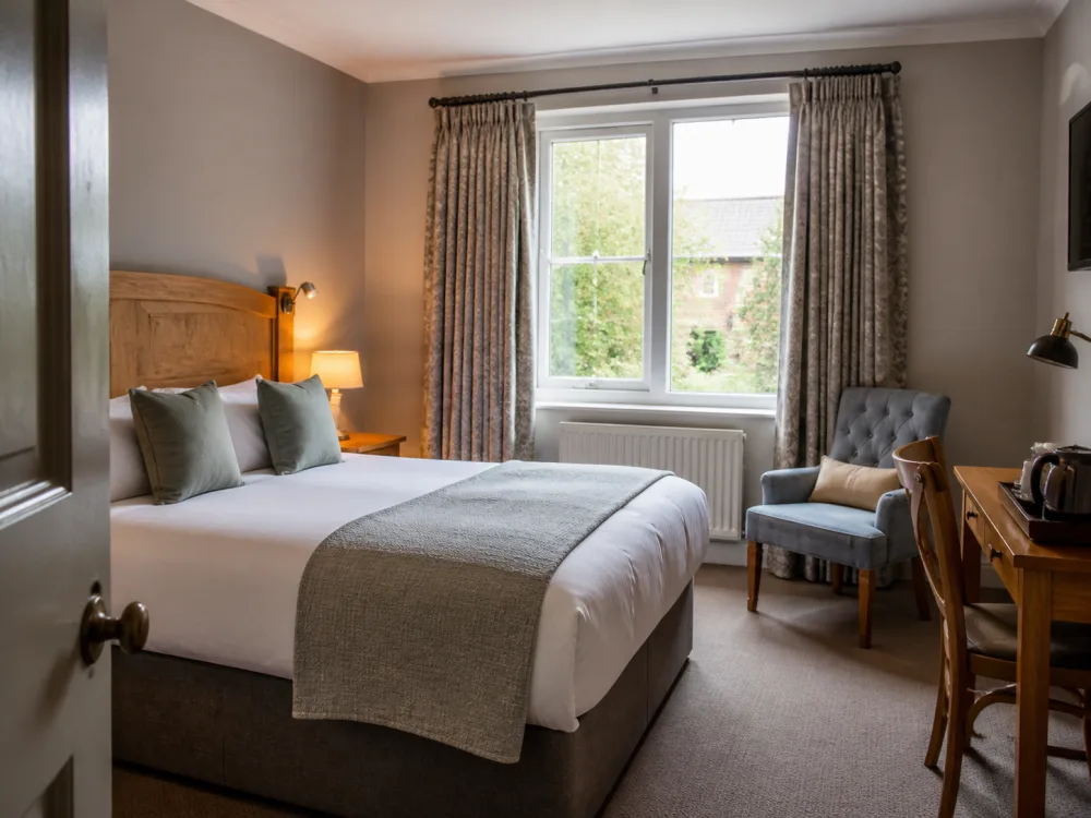 A comfortable independent hotel bedroom with a garden view