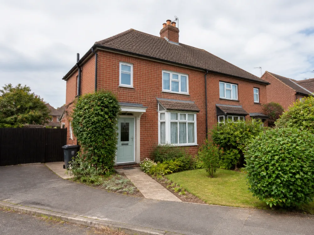 A red-brick English house with a small front garden